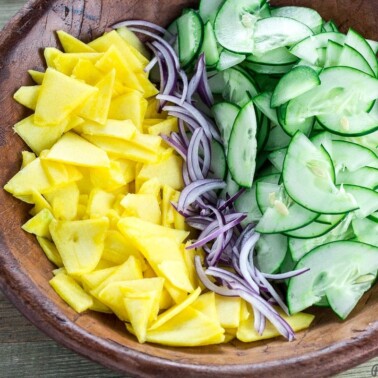 Sliced cucumber, mango and onion in a bowl