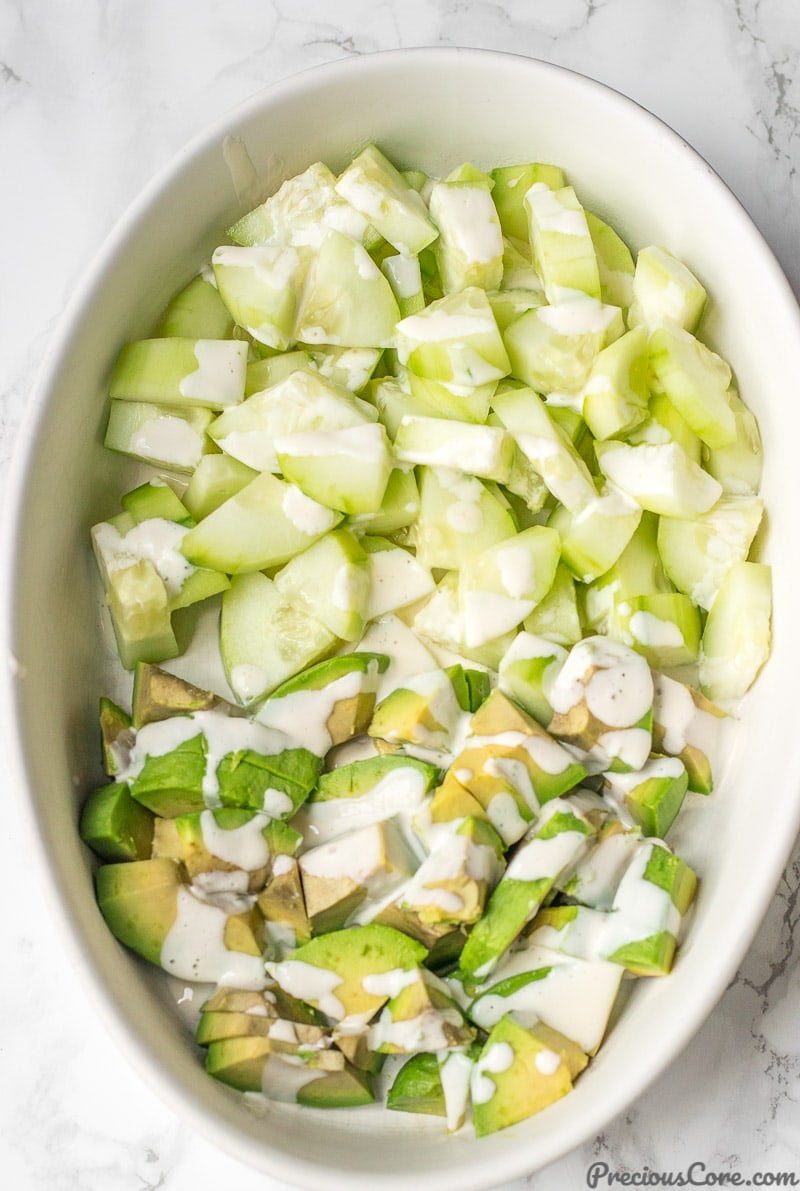 Cucumber Avocado Salad in a bowl with Mayonnaise Dressing drizzled on top