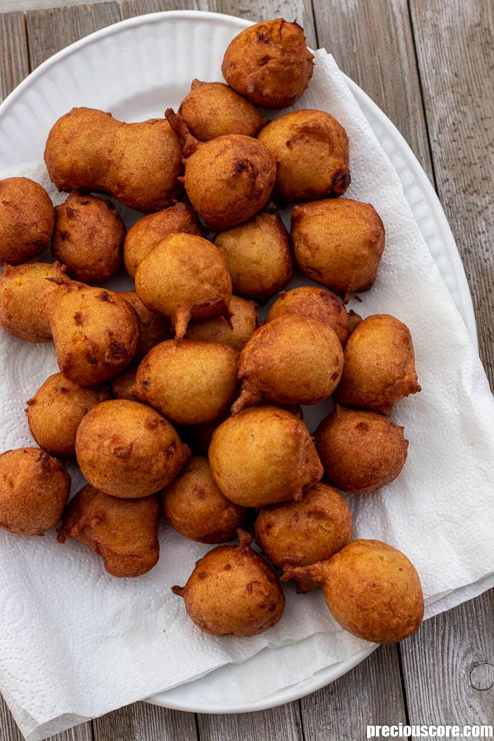 Banana fritters on a platter lined with paper towels.
