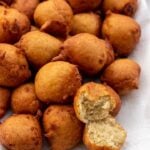 Banana fritters on a platter with one opened up to show texture