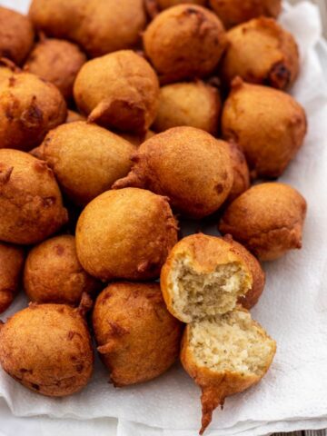 Banana fritters on a platter with one opened up to show texture