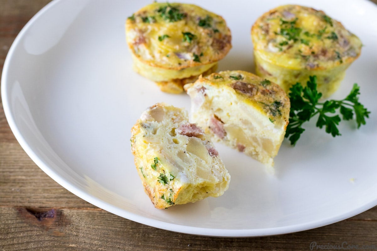 Egg Muffin Cups on a plate, one of which is cut in half.