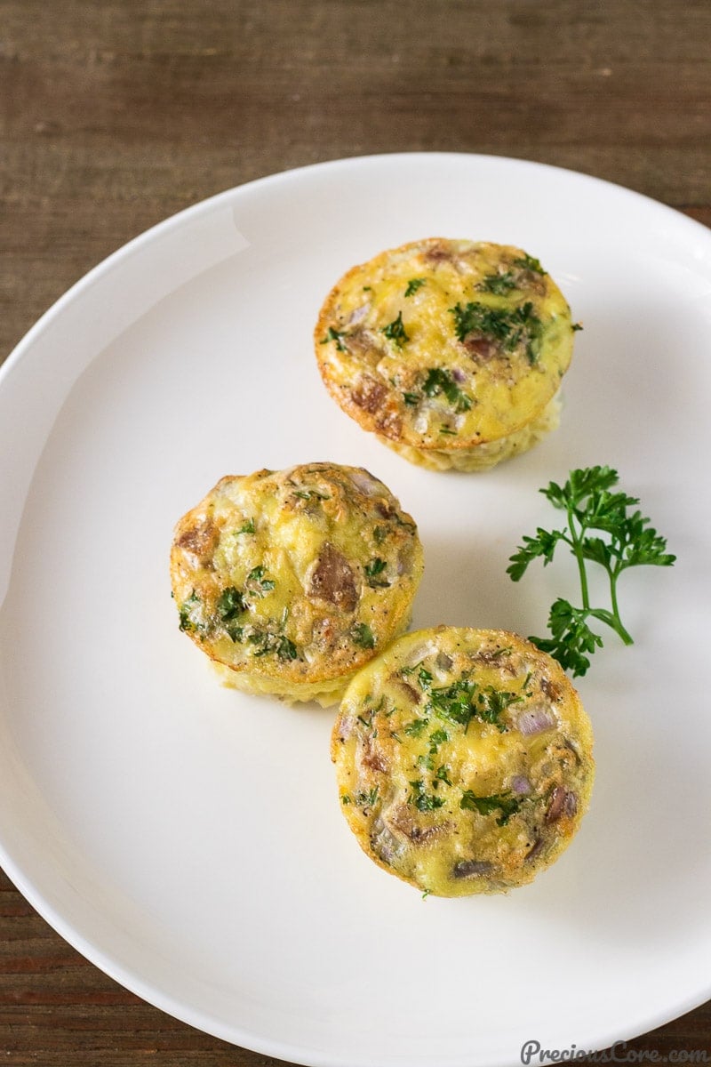Egg Muffin Cups with potato and sausage on a white plate.