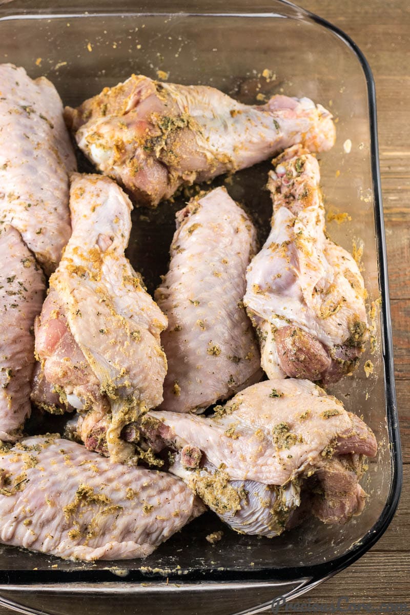 Seasoned turkey wings in a baking dish.