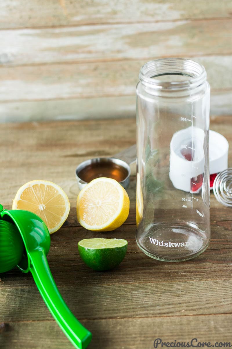 Whiskware dressing shaker next to citrus and honey.