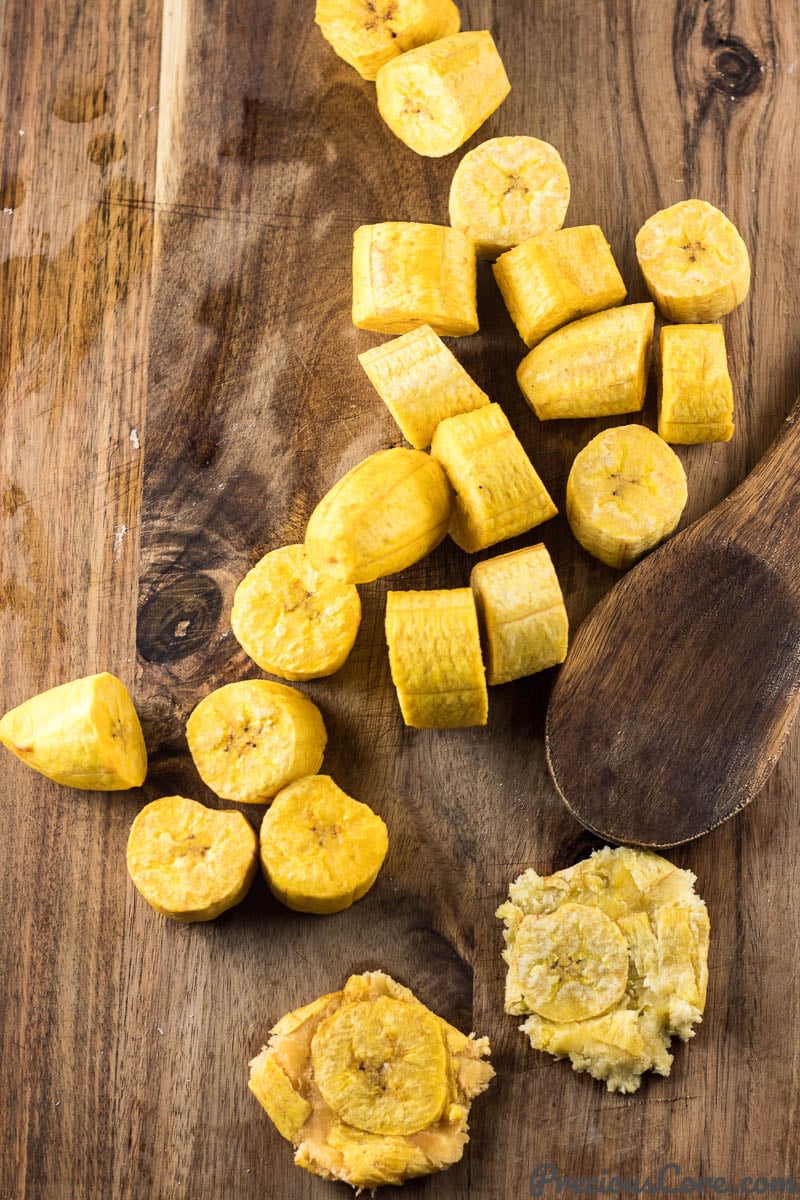 Wooden spoon with flattened plantains.