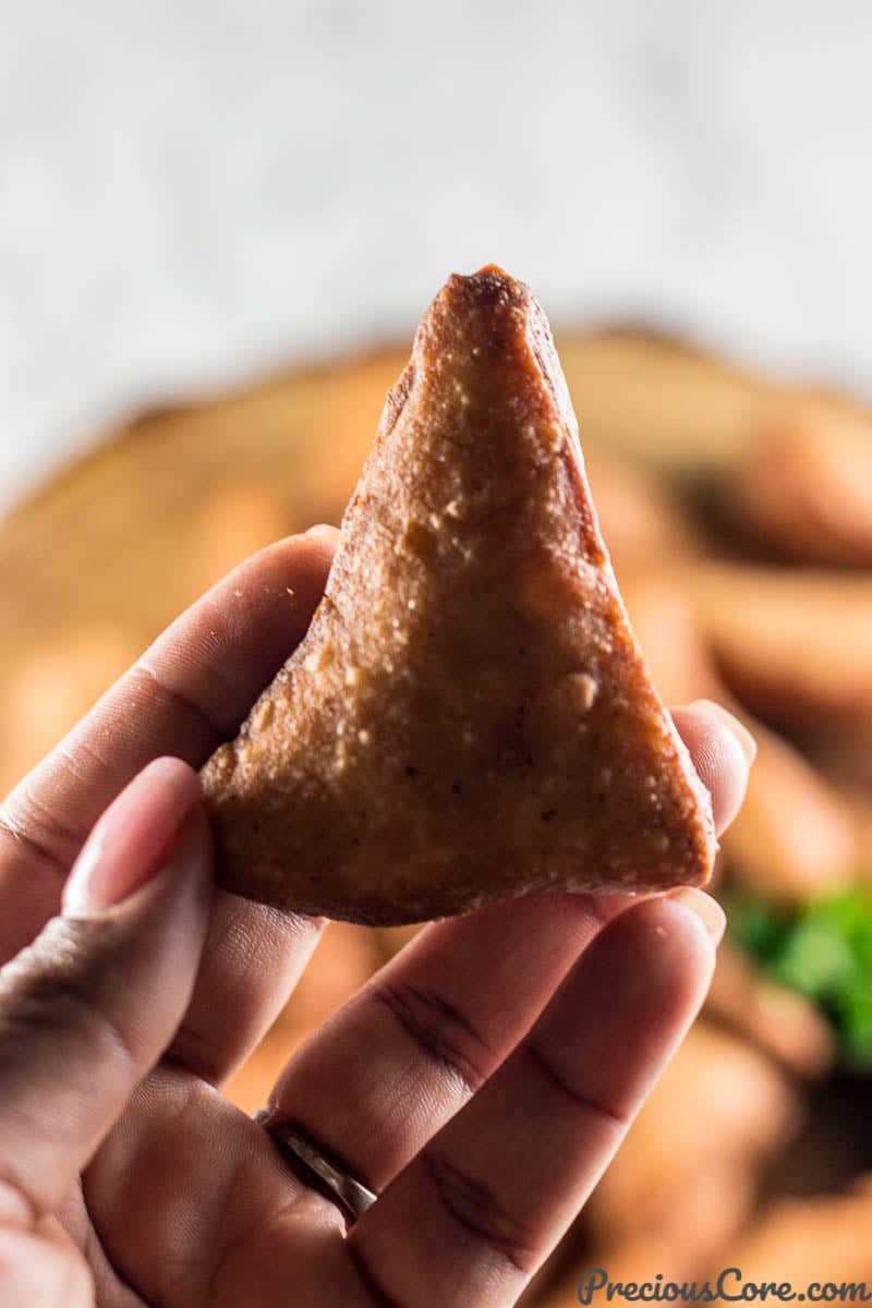 Person holding a Mandazi, or East African doughnut.