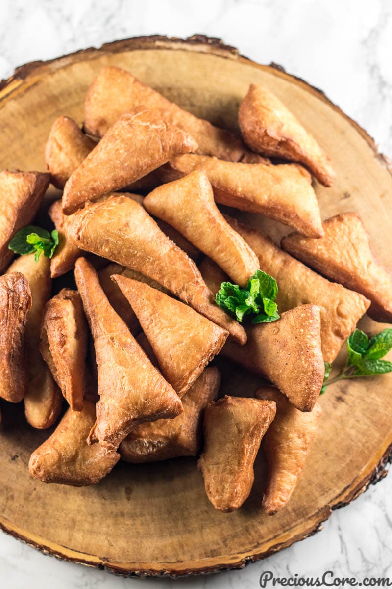 Mandazi on a brown serving platter.
