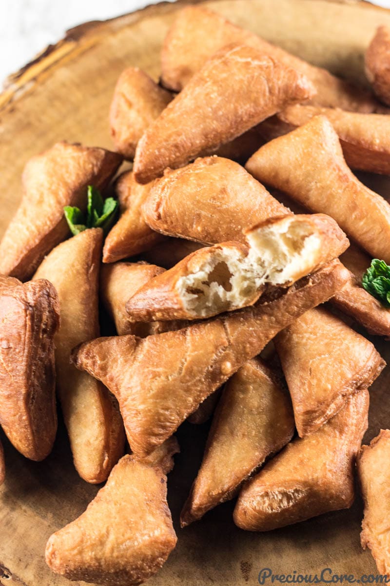 Pile of Mandazi, one of which is missing a bite.