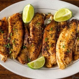 Pan Seared Tilapia on a serving tray with lime wedges