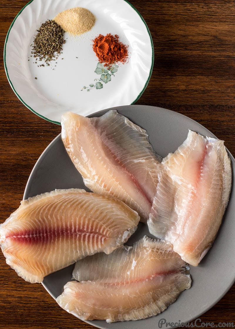 Tilapia Fillets on a Plate and Dried Spices on a Plate