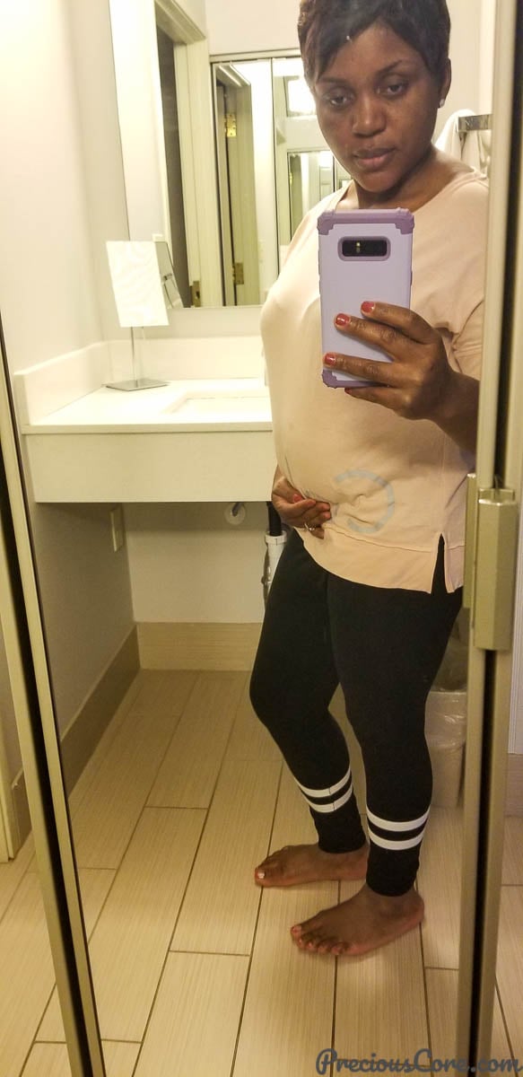 Woman holding phone taking selfie - first trimester