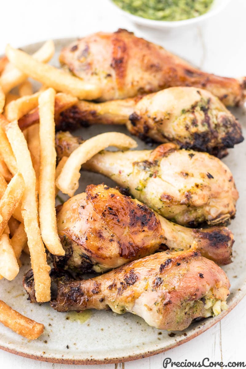 Chicken and fries on a plate with green sauce on the side