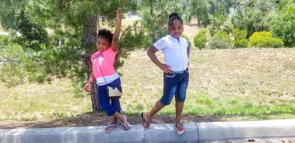 Two girls posing on a curb.