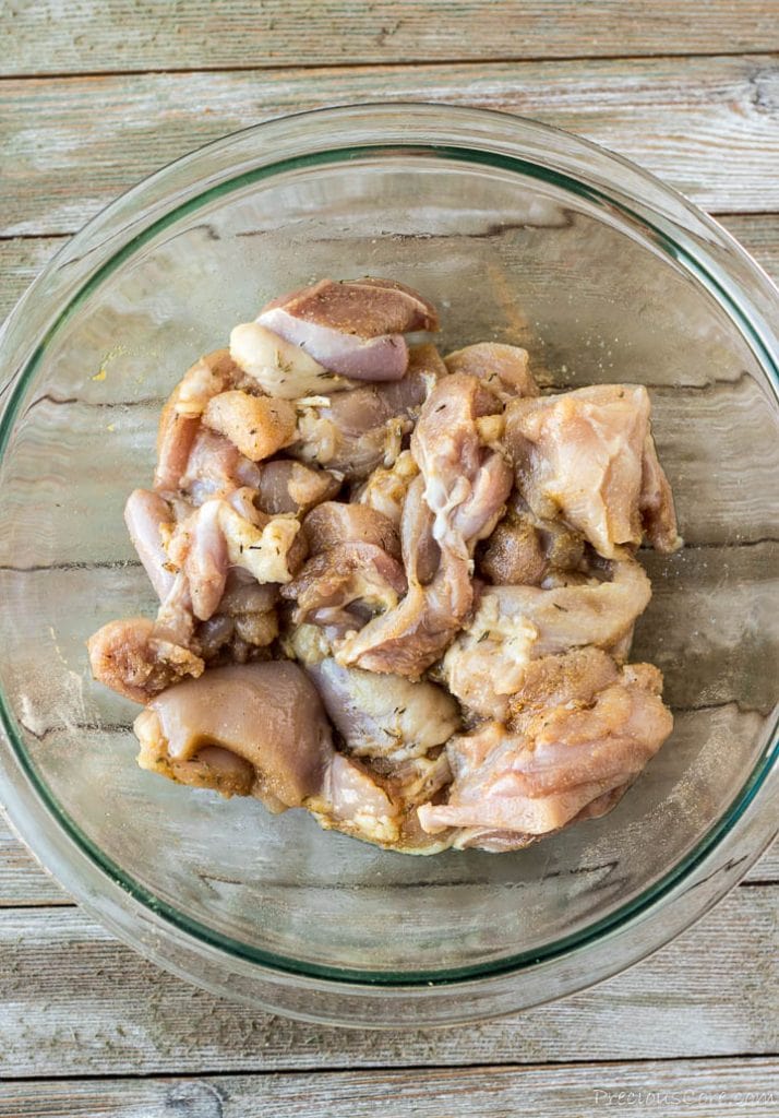 Chunks of chicken in a bowl mixed with spice rub