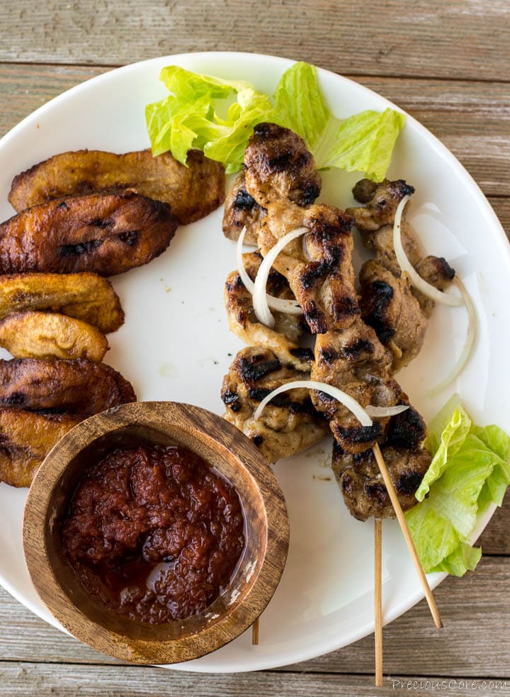 Chicken skewers on plate with fried plantains