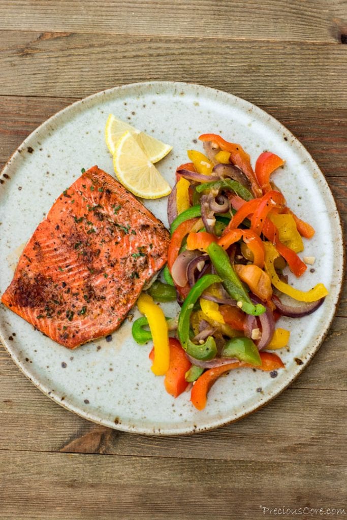 Cajun salmon, sauteed peppers and lemon slices on a plate