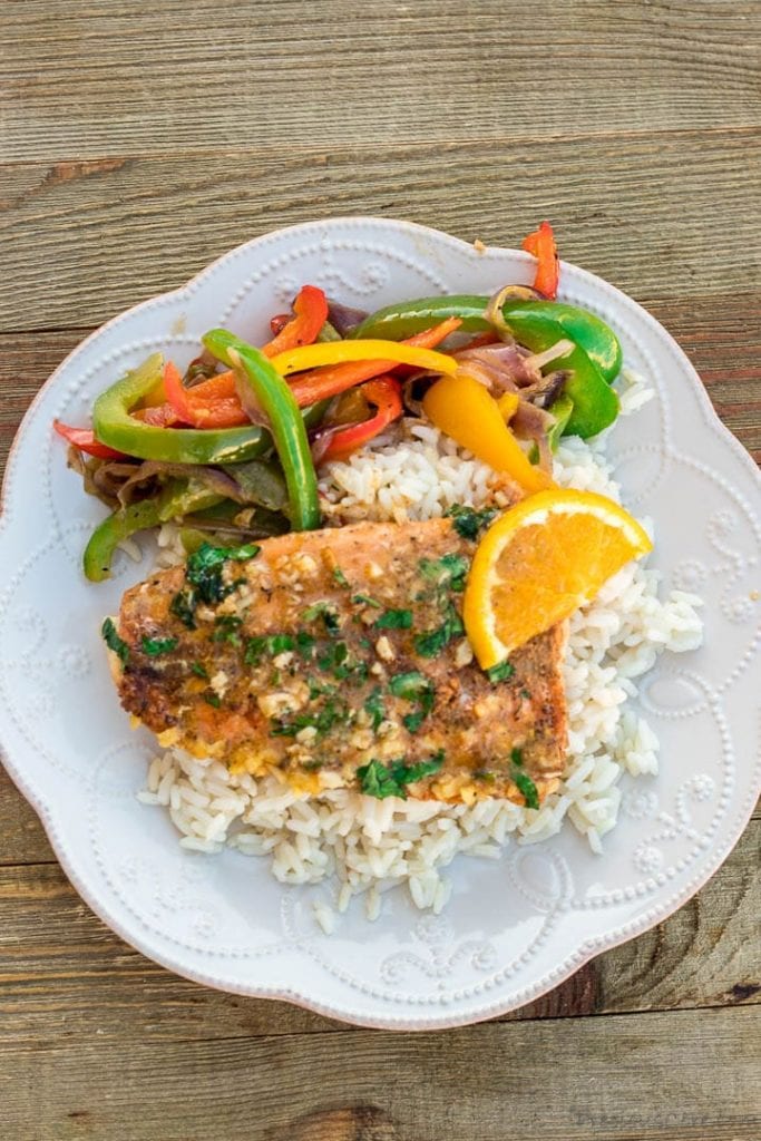 Plate of sauteed peppers, rice and baked salmon