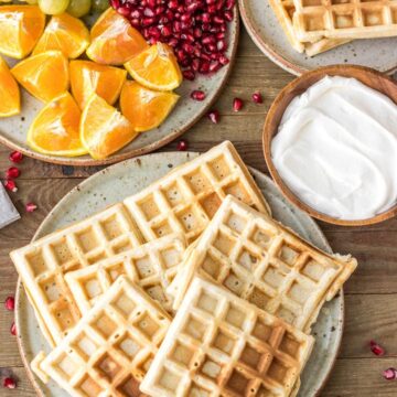 Homemade Waffles on a plate with whipped cream on the side