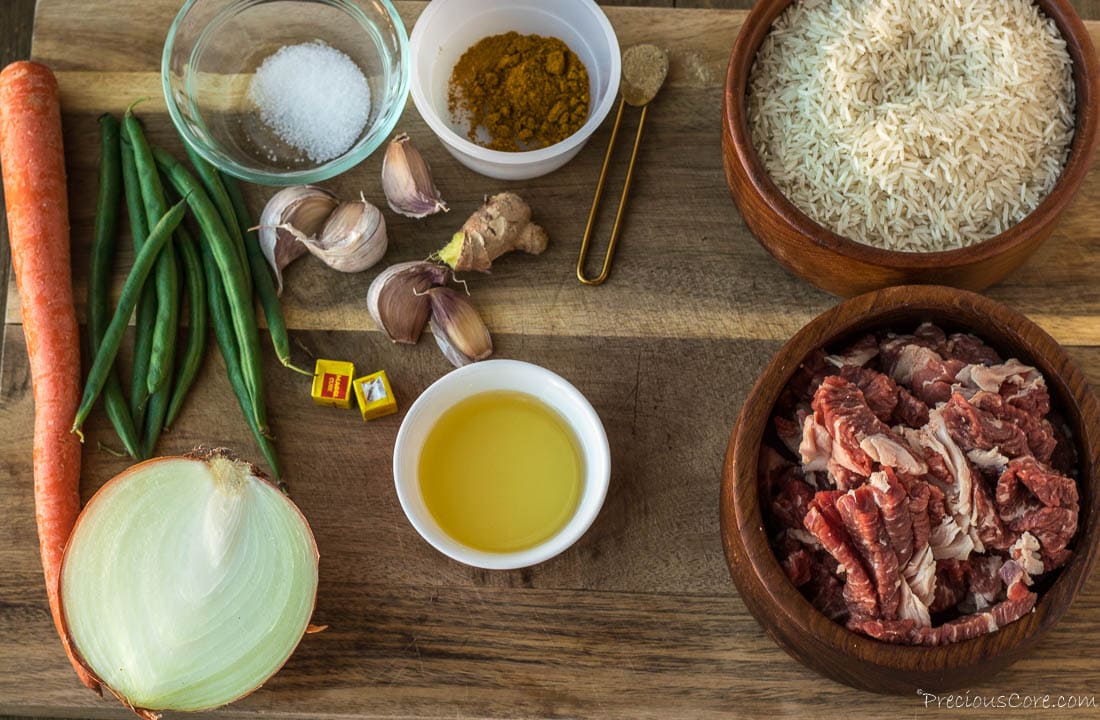 Beef rice, spices and oil on a chopping board.