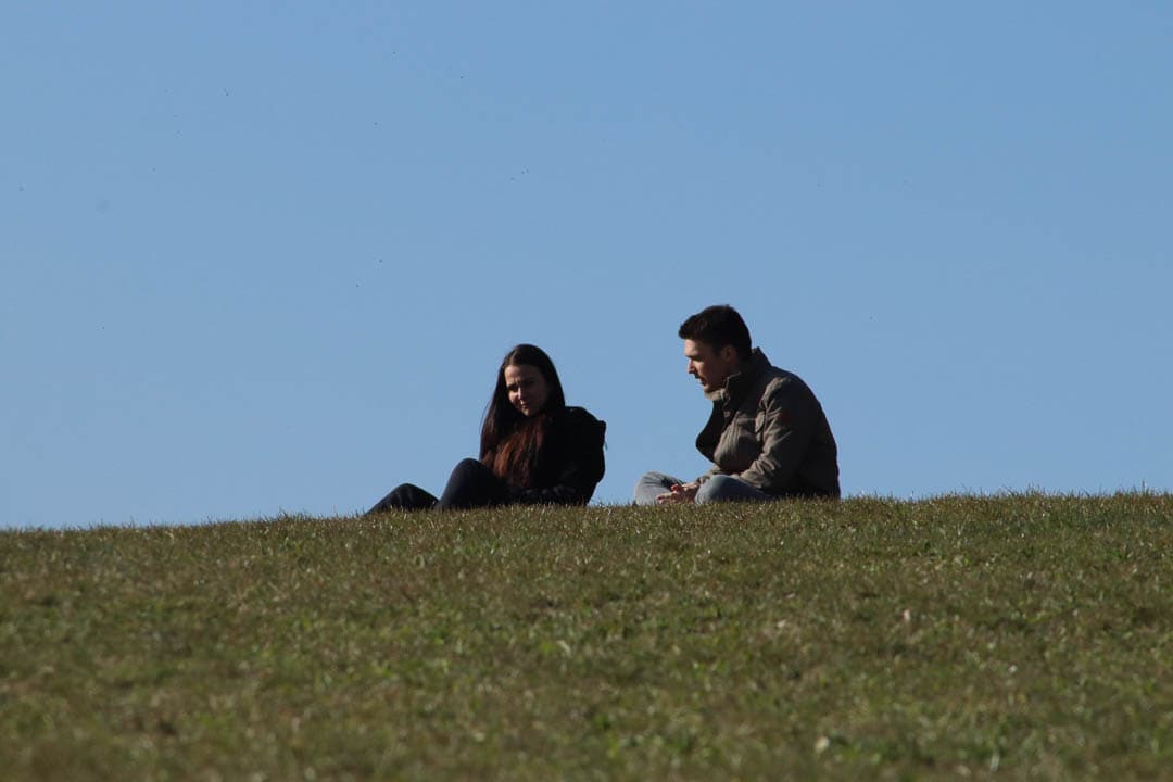 man sitting on grass with woman