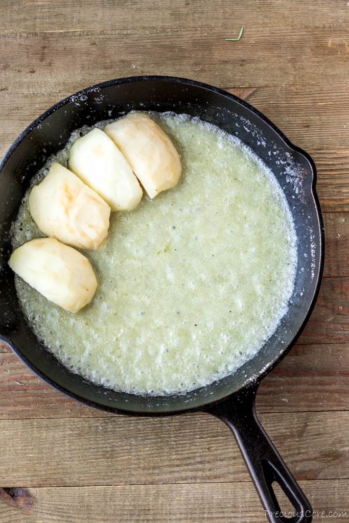 Apple slices over melted butter and sugar