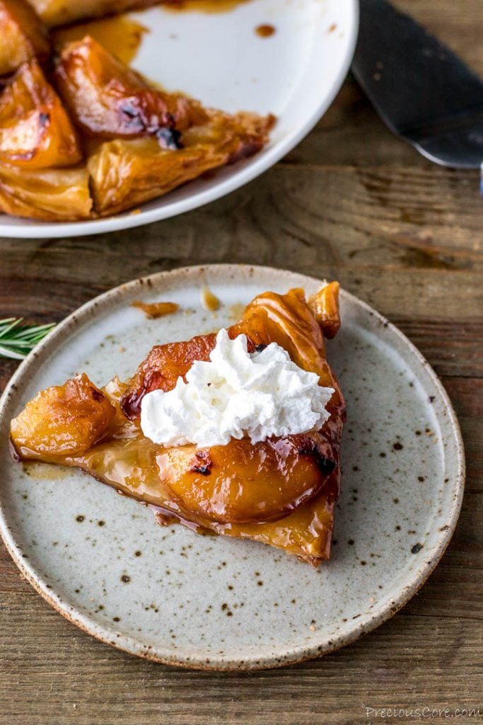 Slice of tarte tatin with whipped cream on top