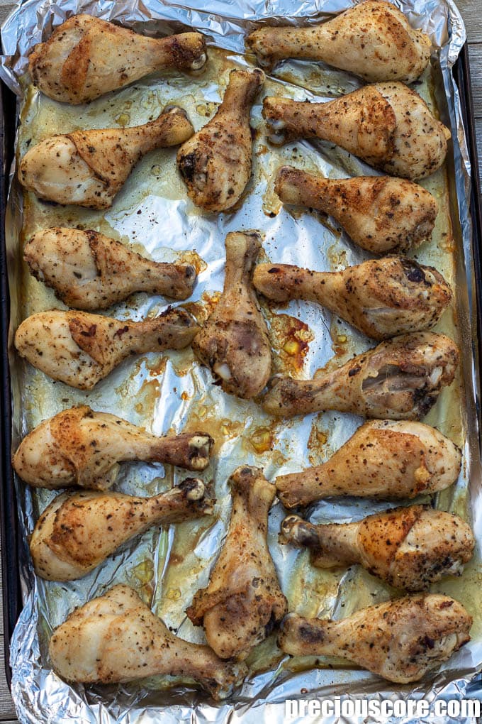 Baked drumsticks on baking sheet.