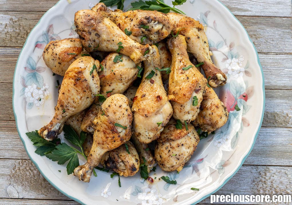 Oven baked chicken drumsticks or legs on a serving platter.