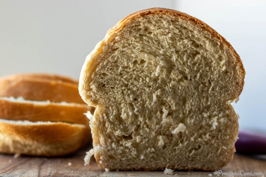 Half a loaf of homemade bread with bread slices on the side