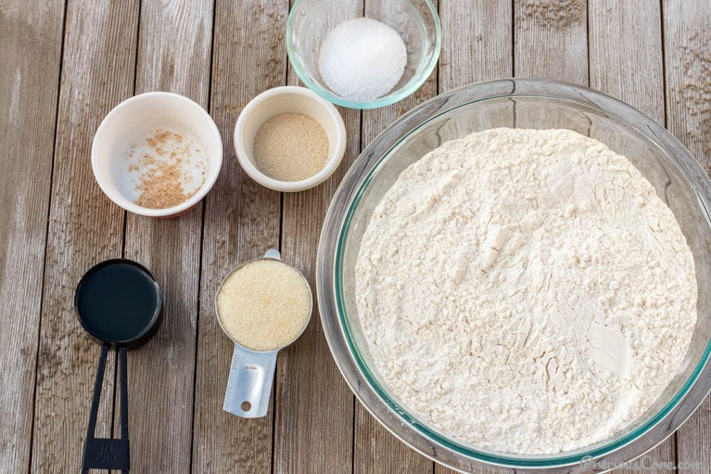 Ingredients for homemade bread in bowls and measuring cups