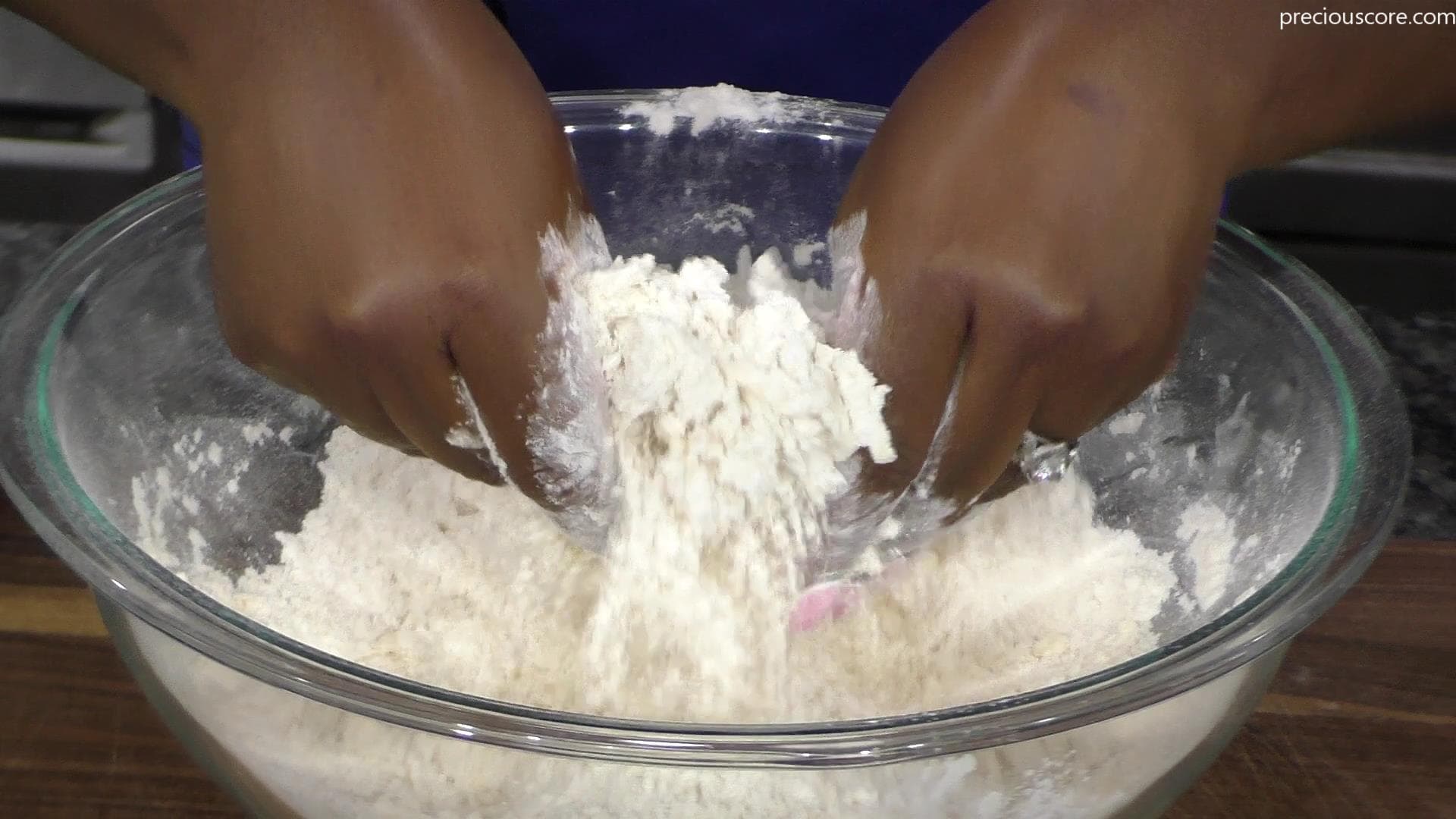 Hands mixing butter and flour together.