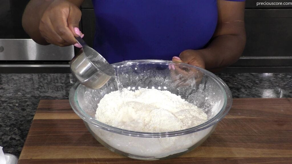 Hand pouring Sprite into mixing bowl.