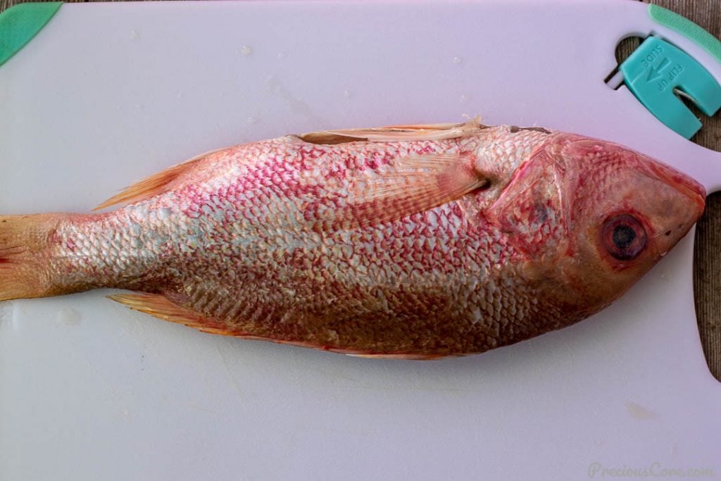 Raw whole red snapper on a chopping board