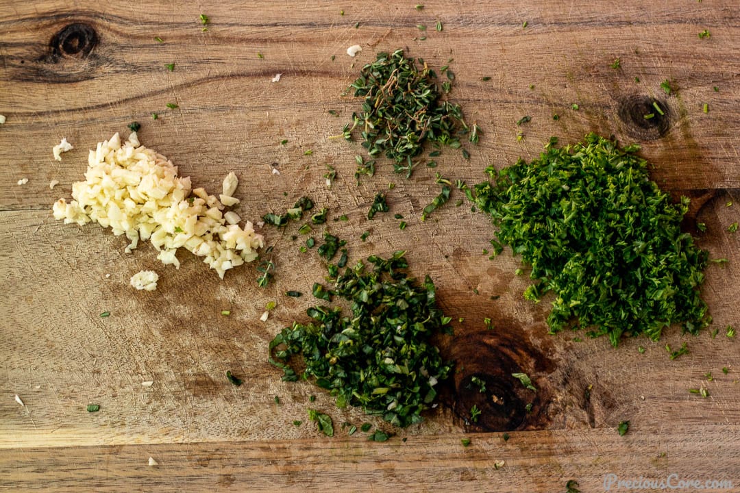 Minced herbs and garlic on a chopping board