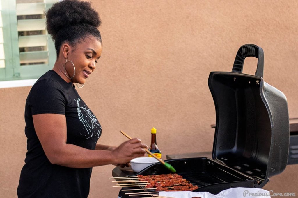 Woman basting skewered meat on the grill - Cameroonian Street Food