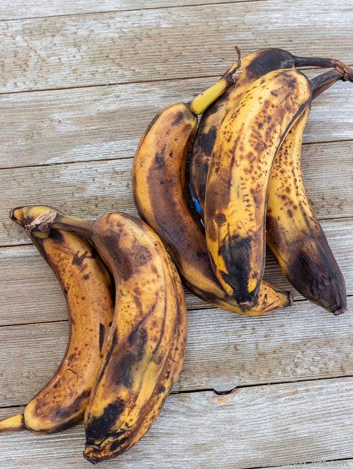 Overripe bananas on wooden surface.