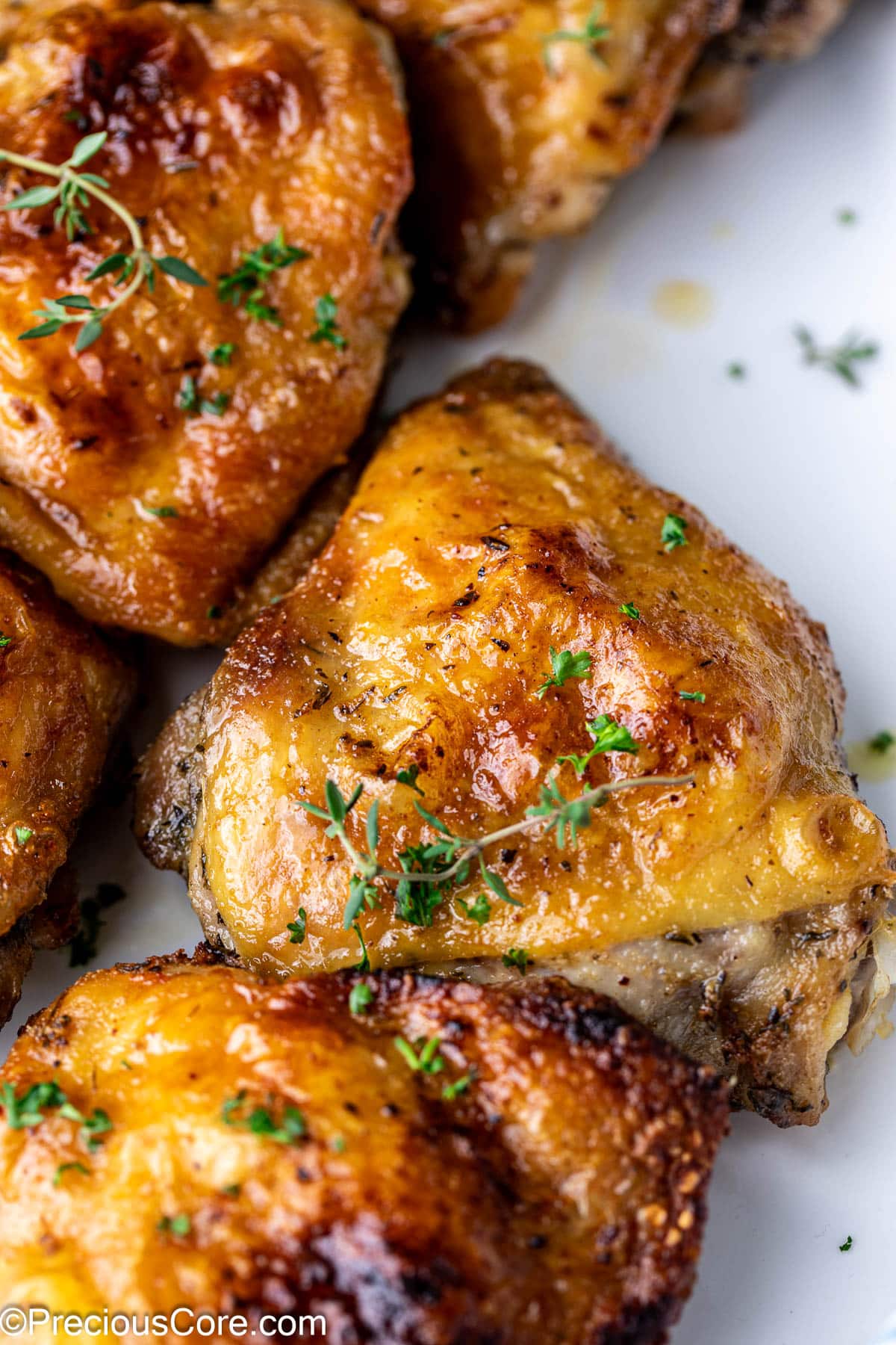 Zoom in on a chicken thigh garnished with fresh thyme.