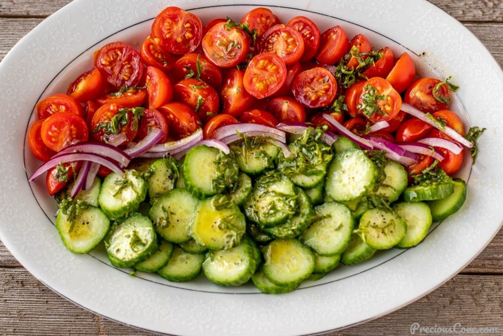 tomato cucumber salad with dressing drizzled on top