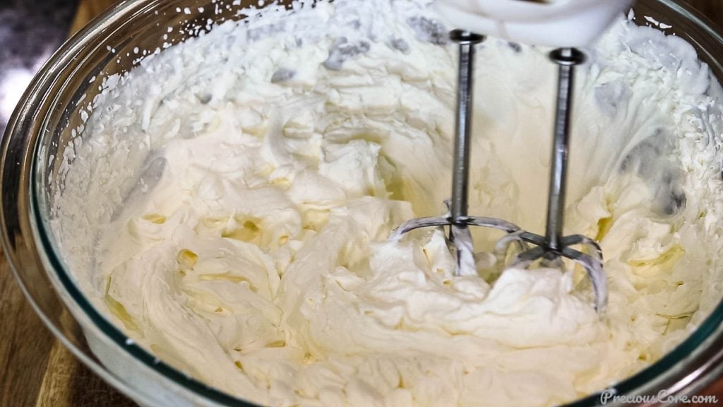 Whipping cream in a bowl beaten to stiff peaks