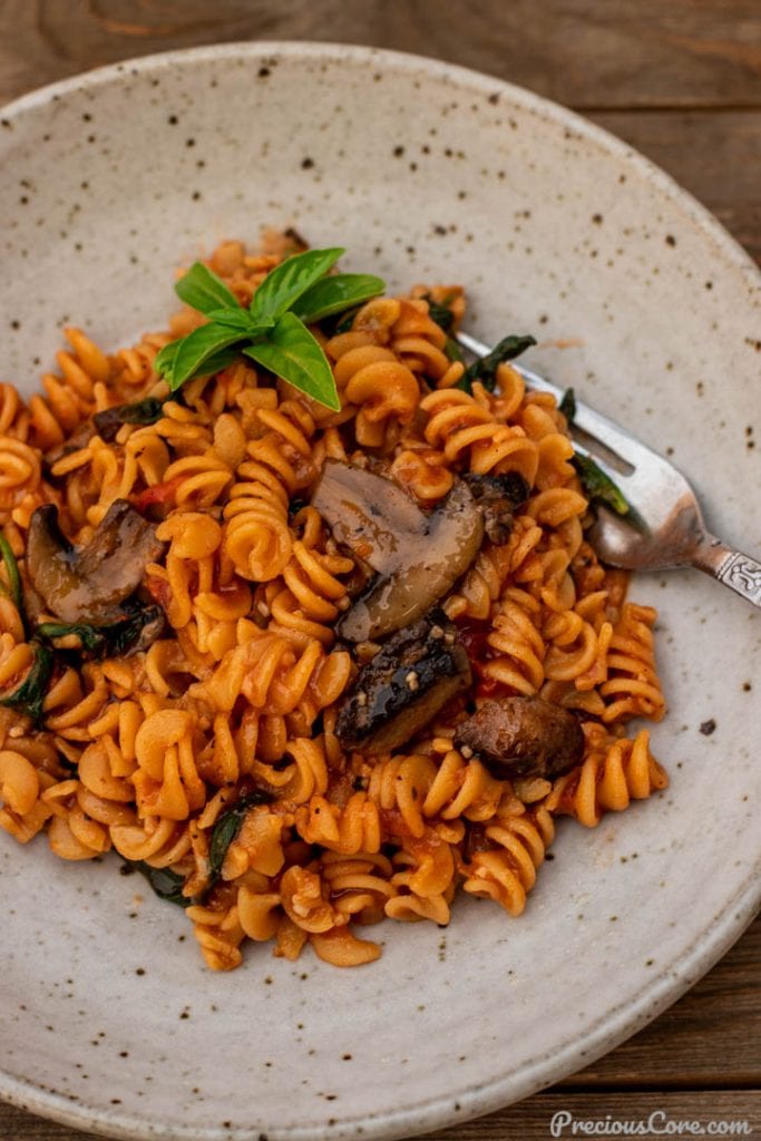 Bowl of pasta with spinach and mushrooms