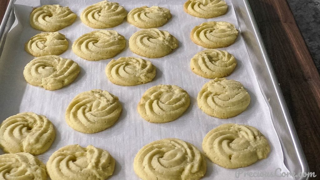 Freshly bakes butter cookies on baking sheet.