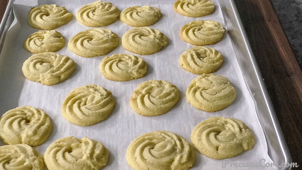 Freshly bakes butter cookies on baking sheet.
