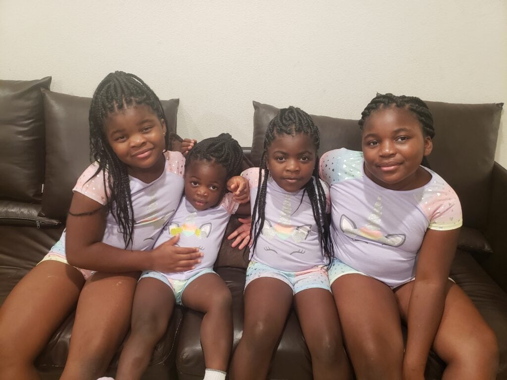 4 brown girls sitting on couch.