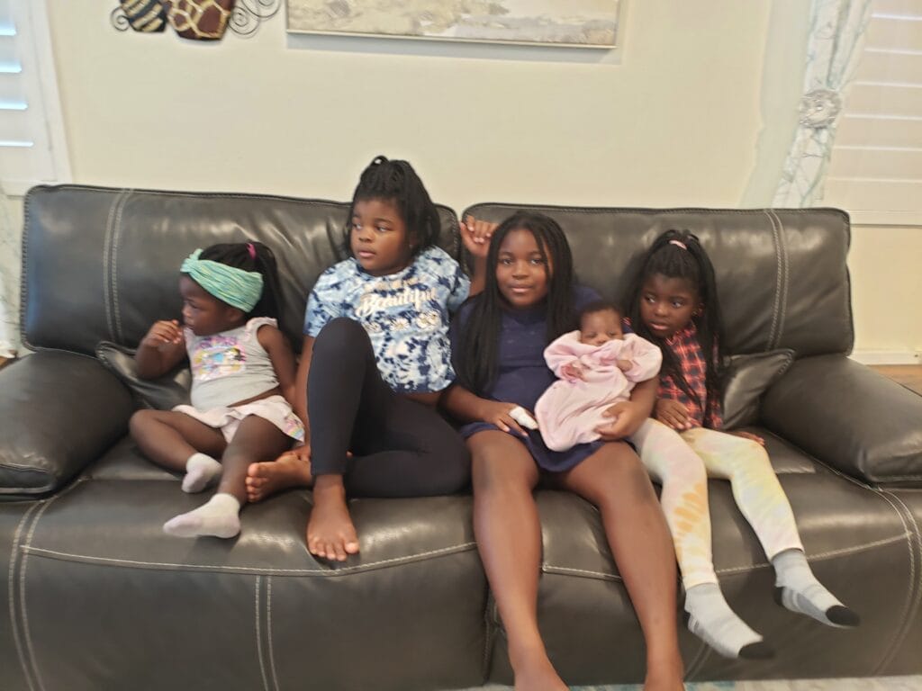 Five girls sitting on couch.