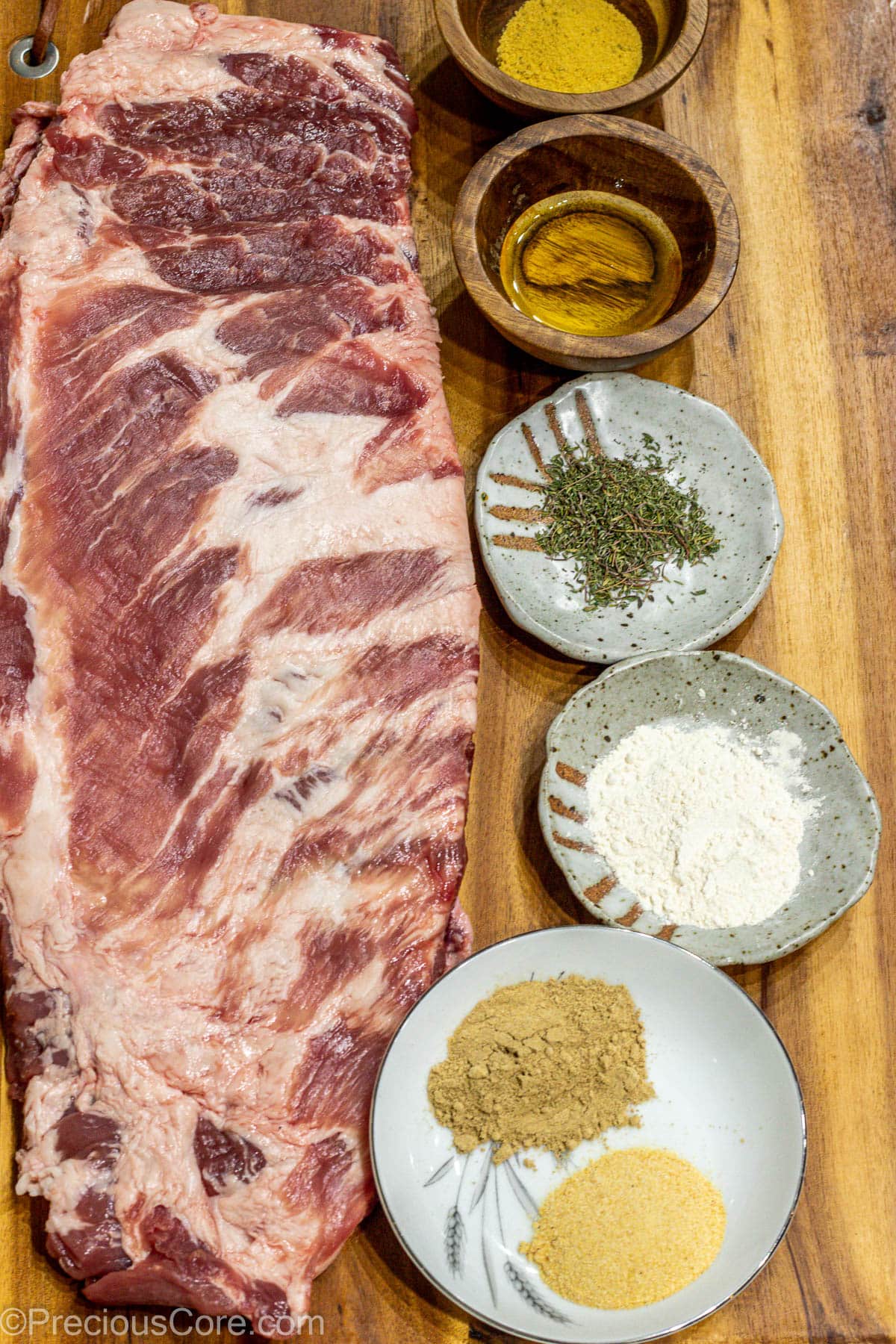 Raw ribs, spices, and salt on a chopping board.