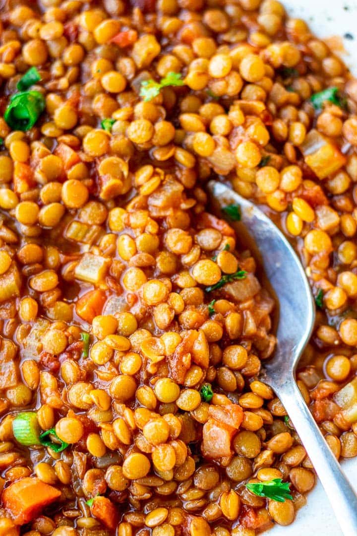 Spoon digging into a bowl of Lentil Stew.