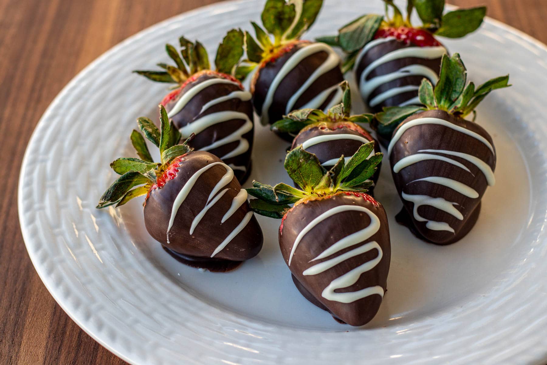 landscape photo of chocolate covered strawberries on a plate