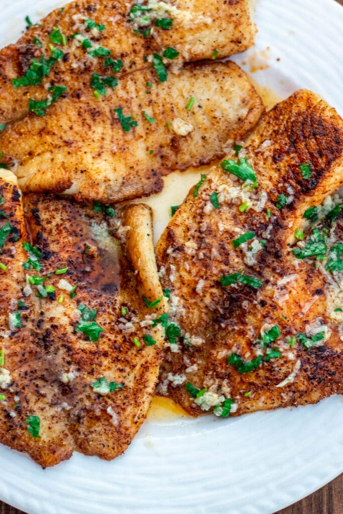 Cooked tilapia fillets in lemon butter sauce