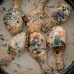 Chicken drumsticks in creamy sauce in a cast iron skillet